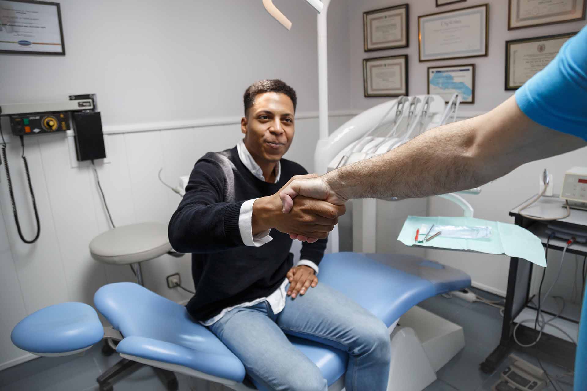 Man in dentist chair shaking hand with dentist at Dentist4