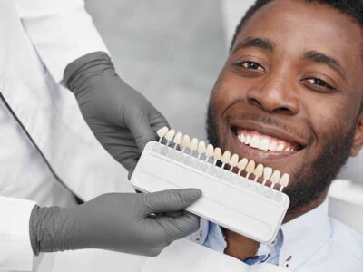 Man smiling while dentist keeps range of fillings colors